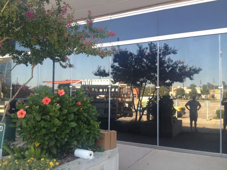 Exterior view of a commercial building storefront with dark solar control window film applied by Amertint for heat reduction
